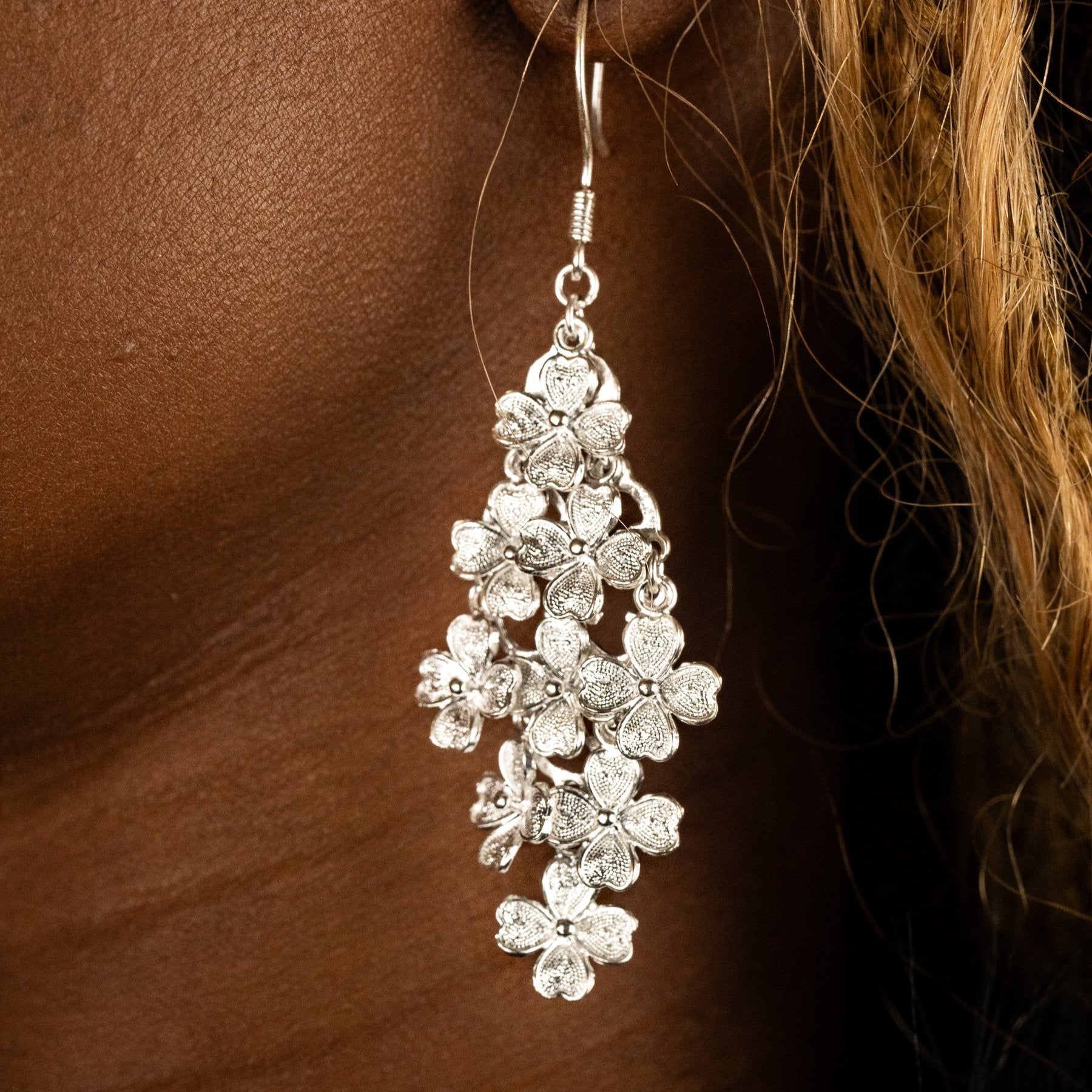 Model wears a fine filigree silver clover earring